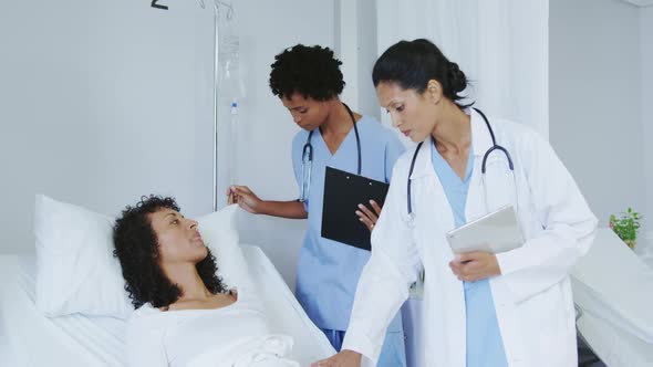 Front view of African american female doctors doing routine check-up in ward at hospital