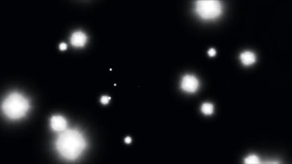 Animation of glowing white spots of light moving in hypnotic motion on black background