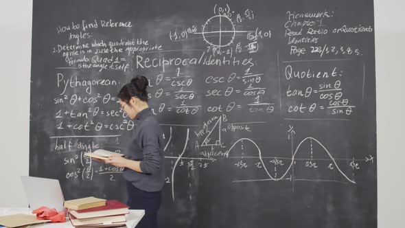 Female Asian Scientist Reading Book in Classroom