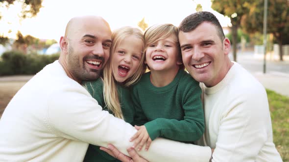 Gay fathers and sons having fun outdoor ay city park - Lgbt family love concept