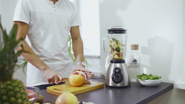 Man Is Squeezing the Juice From Grapefruit To Blender To Make the Smoothie