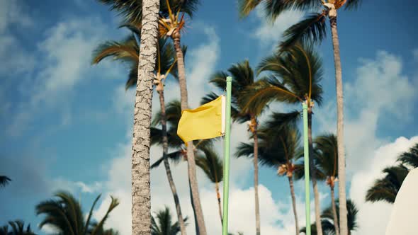 Lifeguard Yellow Flag Waving On Tropical Private Sea Beach On Caribbean Resort Clouds On Background.