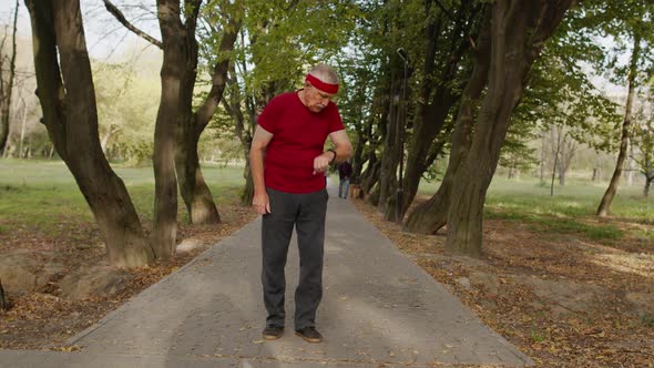 Senior Old Man Running in Park and Using Smart Watch, Tracking Result During Fitness Workout