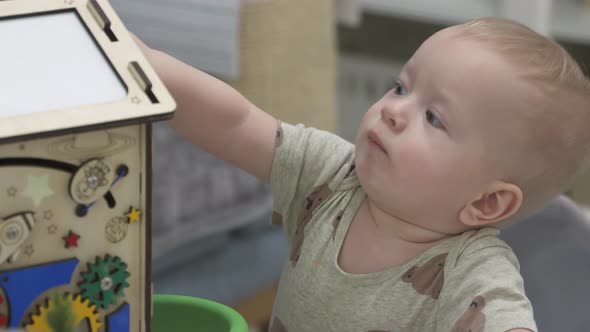 Baby Boy Playing with Wooden Busy House Montessori Educational Toy at Home