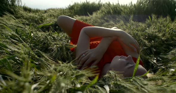 Sexy Woman Is Lying Inside Ears of Wheat in Summer Day, Relaxing and Resting Alone