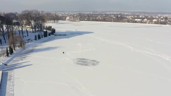 Fisherman Is Fishing Alone on Frozen River