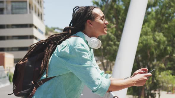 Mixed race man using his phone outside