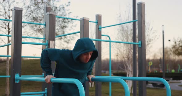 Athletic Man Doing Pushups on the Bars