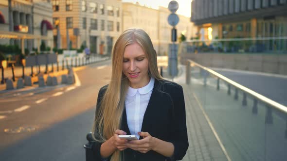 Formal Business Woman Walking on Street. Elegant Blond Girl in Suit and Walking on Street and