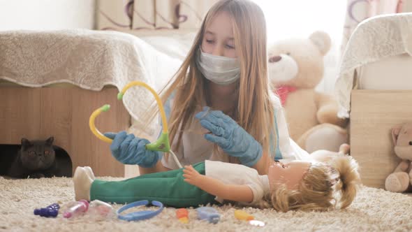 Beautiful Little Girl Playing Doctors with Doll at Home