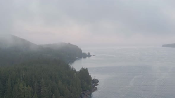 Aerial View of a small secluded town on the Pacific Ocean Coast during a cloudy summer sunrise. Take