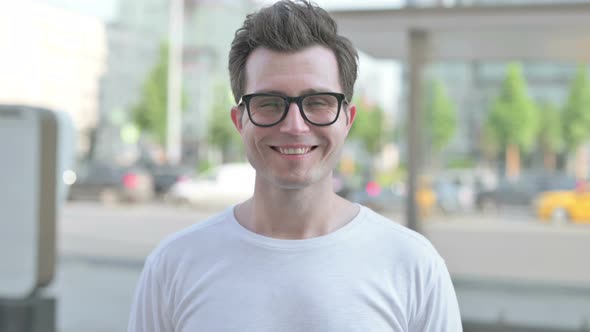 Portrait of Young Man Smiling at Camera Outdoor