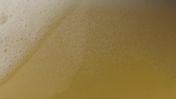Beer with bubbles into the glass in slow motion