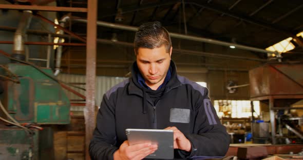 Worker using digital tablet in foundry workshop 4k