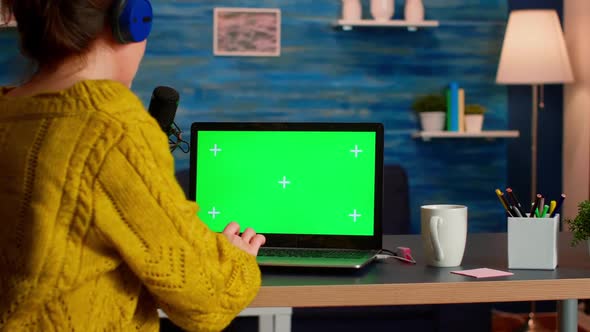 Blogger Typing at Laptop with Green Screen Display