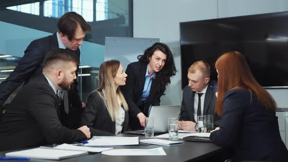 Business People Discussing Progress at Meeting in Office