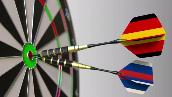 Flags of Germany and Russia on Darts Hitting Bullseye of Target alt