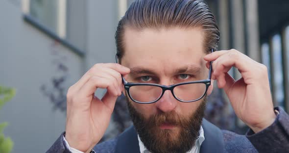 office worker which putting on his eyeglasses and looking at camera with happy smile