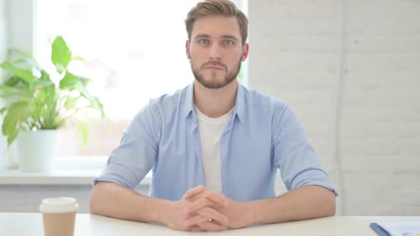 Young Creative Man Looking at Camera in Modern Office