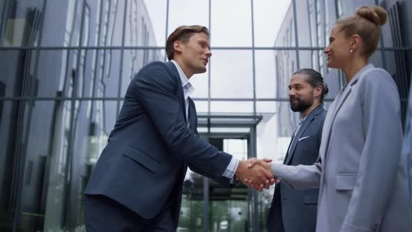 Thankful Leader Shaking Hands Greeting Smiling Team Members at Office Building