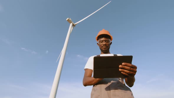 African American Technician Using Digital Tablet While Controlling Working