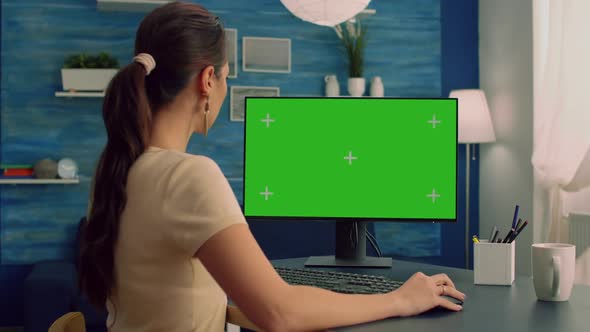 Caucasian Female Typing on Professional Computer with Mock Up Green Screen Chroma Key Display