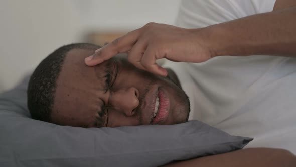 Close Up of African Man Having Headache While Sleeping in Bed