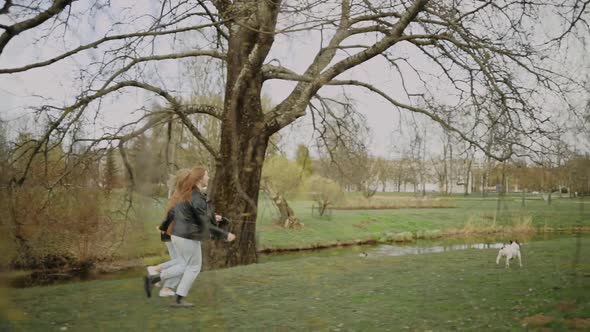 Lesbian LGBT Couple Running and Playing with French Bulldog in Park