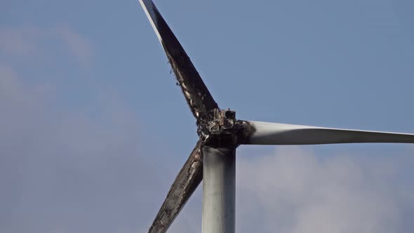 Burned Damaged Wind Turbine Against Blue Sky