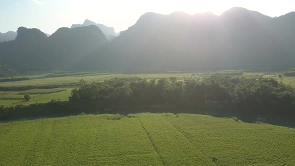 Bright Sunshine From Behind Hills Above Green Fields Gardens