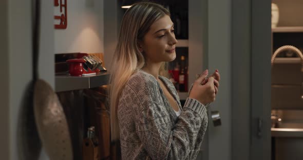 Caucasian woman drinking coffee in her house