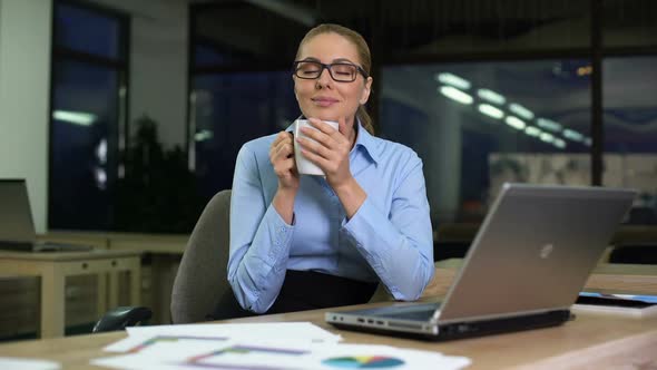 Businesswoman Having Coffee Break on Night Shift in Office, Avoiding Unloved Job