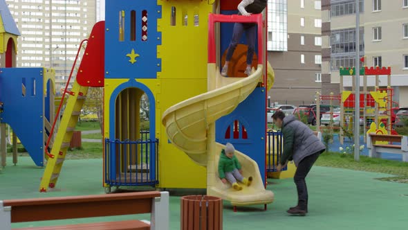 Caucasian Parents and Son Having Fun on Slide in Playground alt