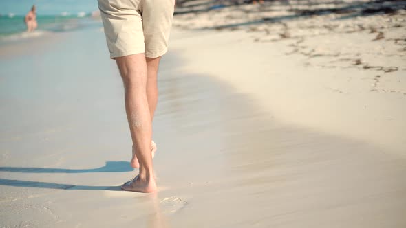 Guy Relaxing On Tropical Beach Resort In Honeymoon Vacation Holiday. Male Walking On Sand.