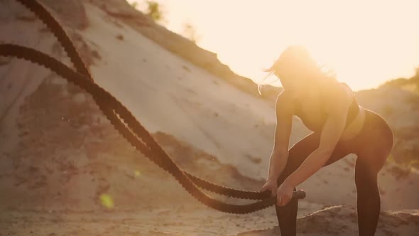 Girl with a Rope Conducts Outdoor Training on the Sandy Ground Near the Beach