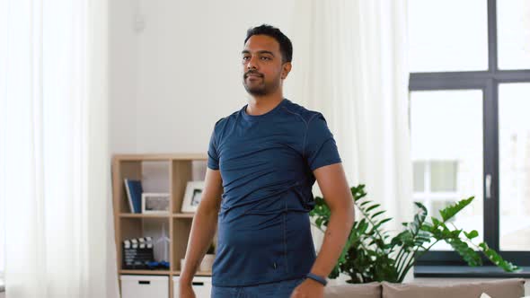 Man with Fitness Tracker Stretching Body at Home