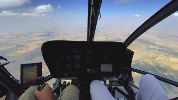 Inside View of a Helicopter in Flight with Pilot and Man Flying a Helicopter on a Sunny Day
