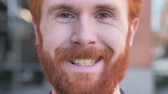 Close up of  Smiling Redhead Beard Young Man Face