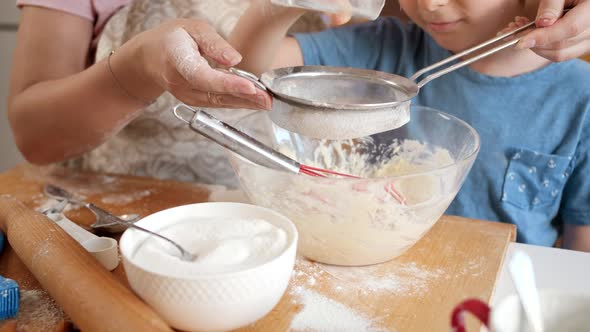 Closeup of Little Boy with Mother Sifting Flour with Sieve