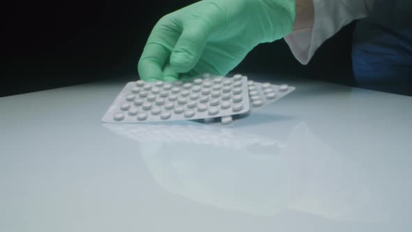 Lab Worker Putting Tablets in Blister Packs on Table