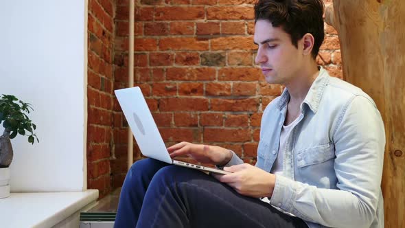 No Young Man Shaking Head to Deny Working on Computer