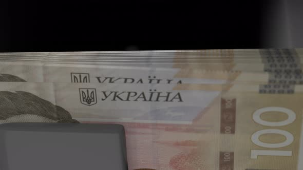 100 Ukrainian hryvnia in cash dispenser. Withdrawal of cash from an ATM.