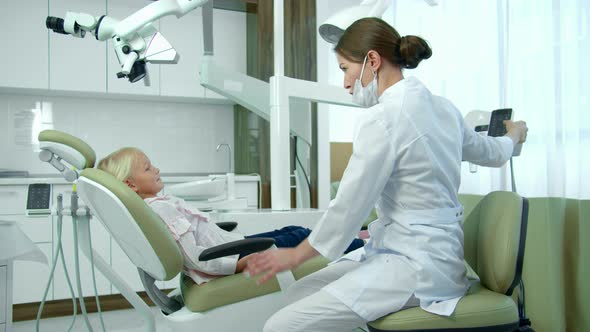 Dentist Moves Chair Back, Little Girl Sits.