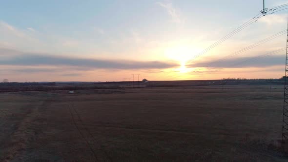 Aerial Video of the Electric Pole with Wires Against Sky at Sunset