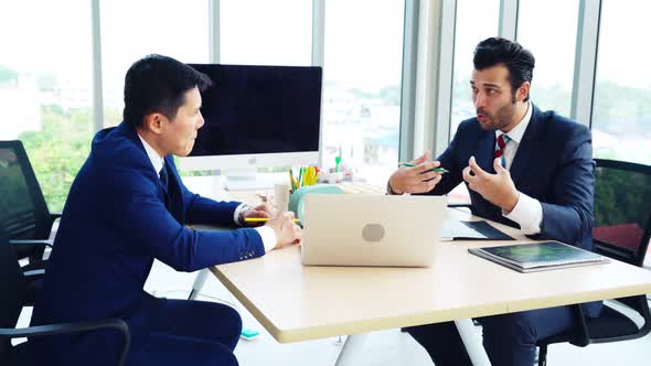 Two Business People Talk Project Strategy at Office