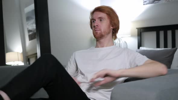Sitting Redhead Man Stands Up and Leaves the Room