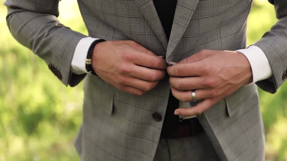 Young Man or Groom Outdoors Getting Dressed in Formal Suit and Buttoning Jacket 1080p 60fps