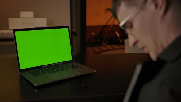 Back View of Male Explaining Equations on Text Tablet Behind Green Screen