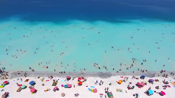 People Swim on Vacation in the White Sandy Beach of the Clear Tropical Turquoise Light Blue Sea