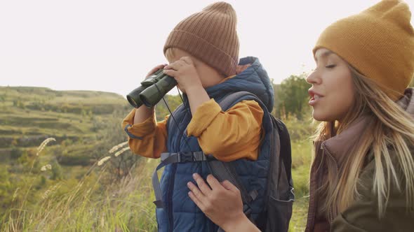 Cute Boy with Binoculars and Mother Enjoying Scenic View
